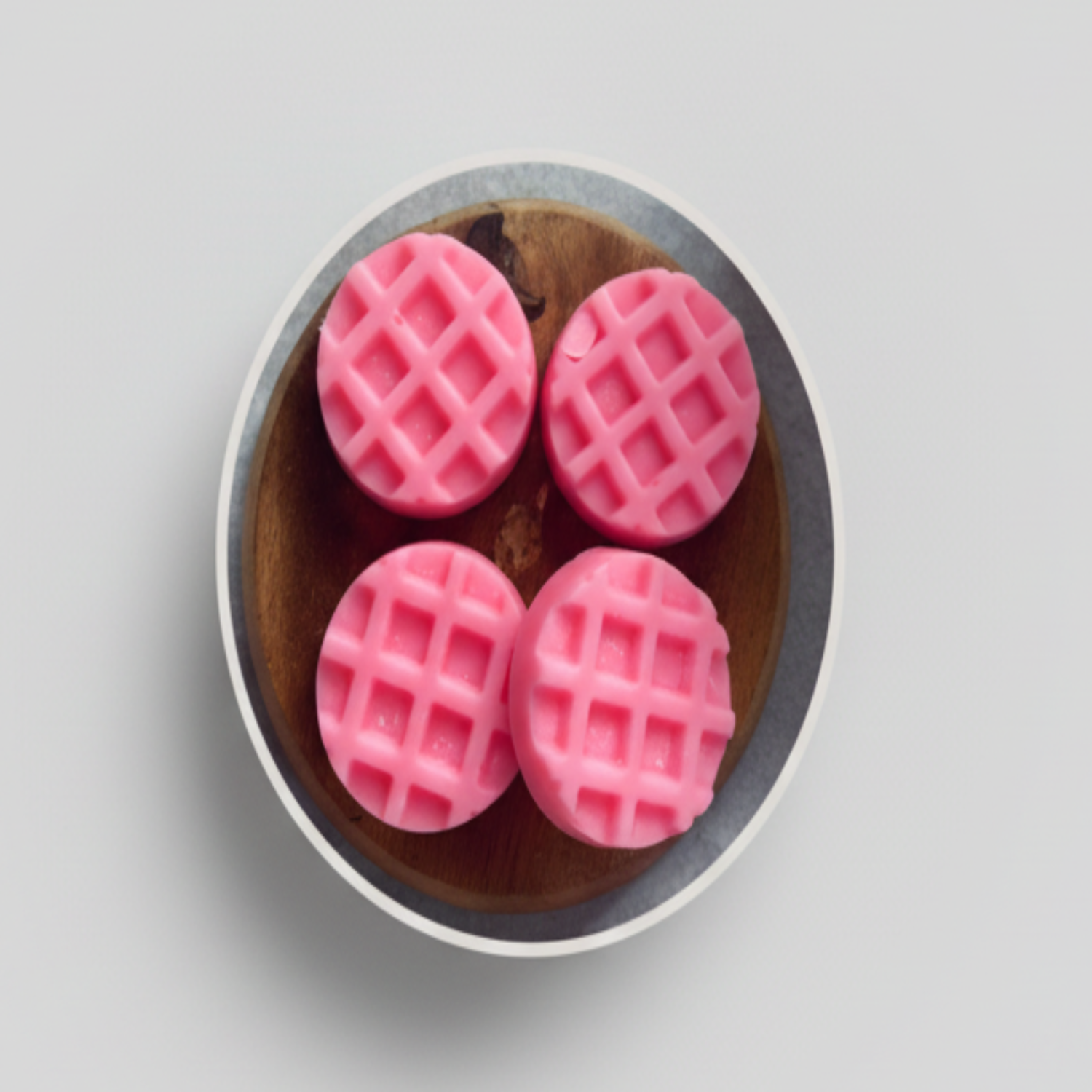 Vier roze wax melts Dupe-Amour My Amor Parfum met rasterpatroon op houten schotel.