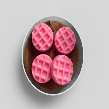 Vier roze wax melts Dupe-Amour My Amor Parfum met rasterpatroon op houten schotel.